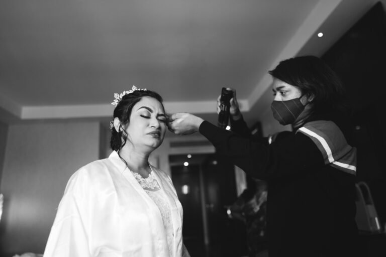 Makeup artist applying bridal makeup to a bride