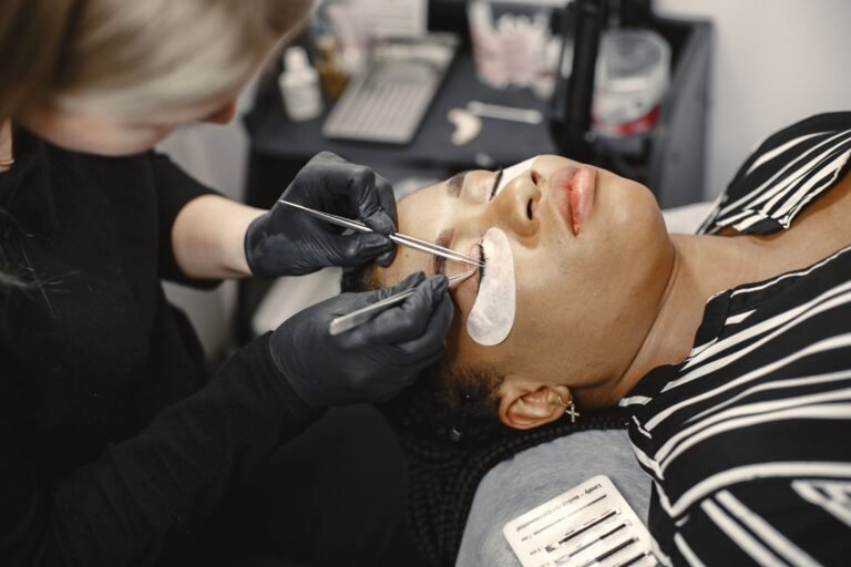 Lash technician applying individual eyelash extensions to a client
