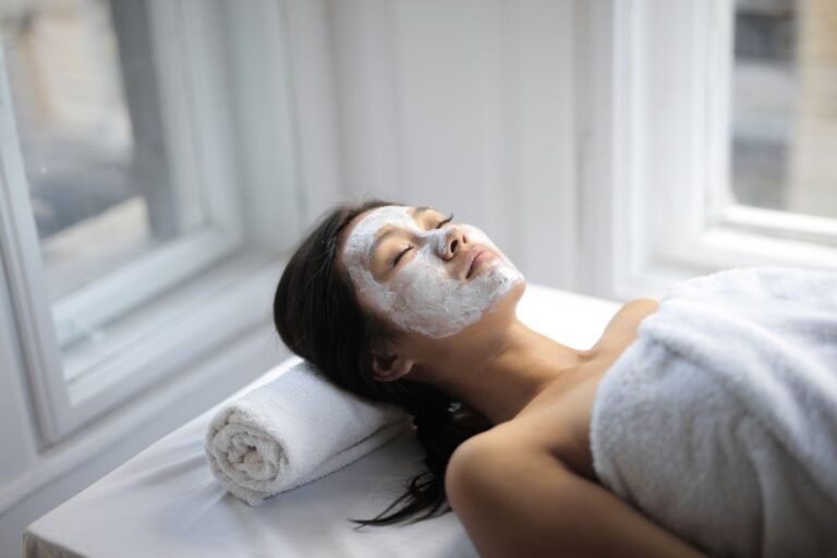 Client relaxing with a hydrating facial mask and towel at a spa