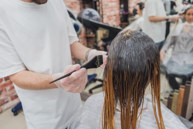 Hairdresser applying color to a client's hair in a salon