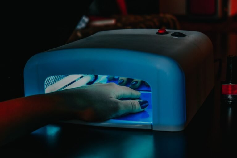 Hand with gel polish curing under a salon UV lamp